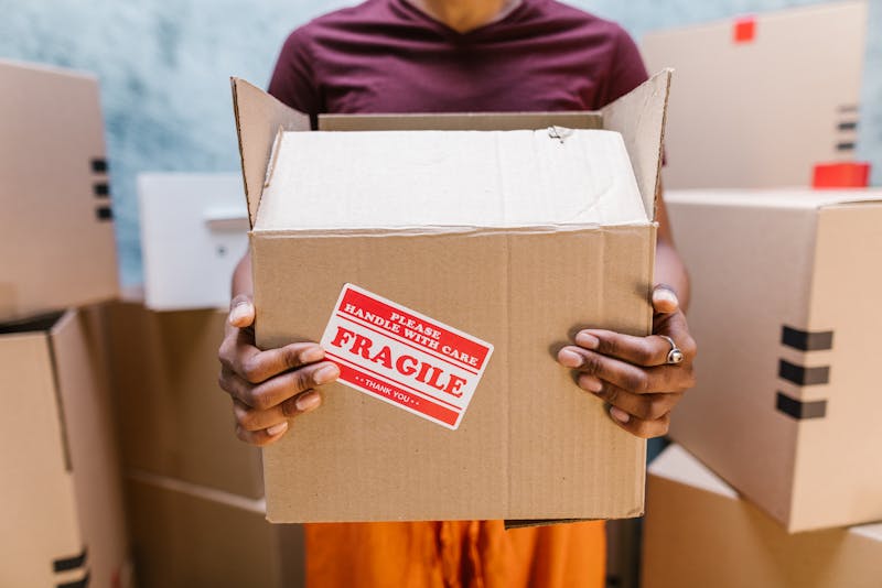 a woman holding a box with a fragile sign